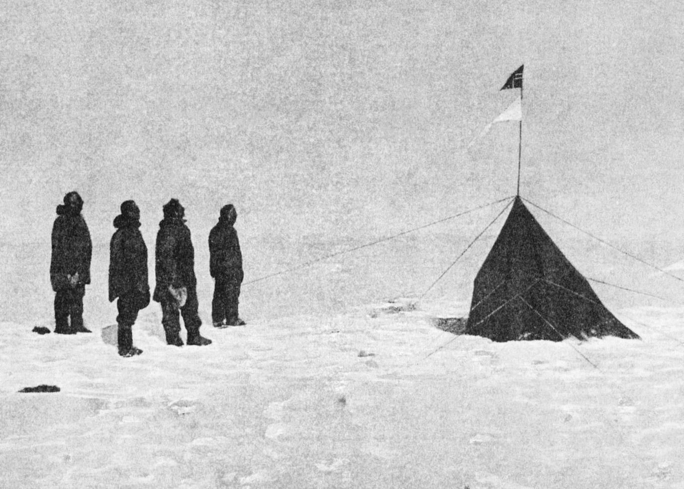 roald amundsen's expedition team at the south pole, december 1911, with the norwegian flag