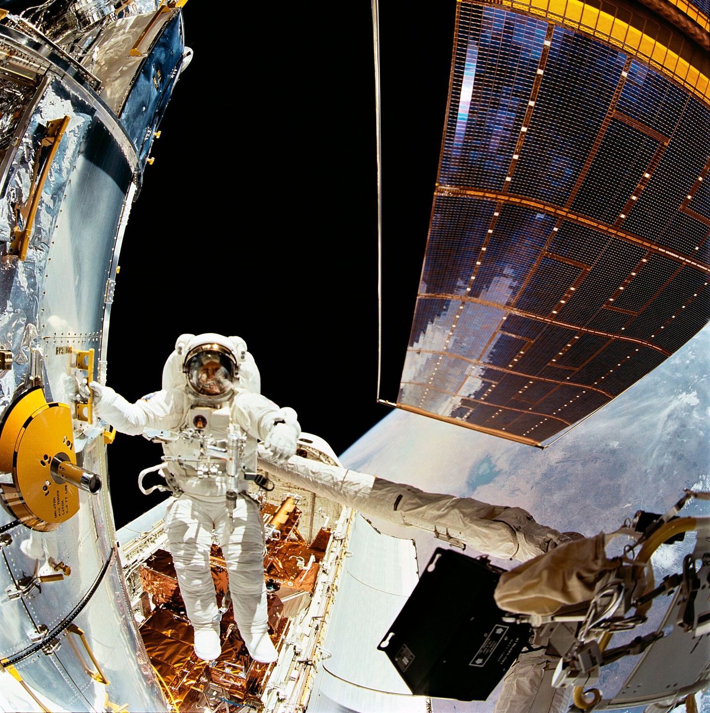 astronaut story musgrave anchored to the shuttle's robotic arm during the first servicing spacewalk on hubble