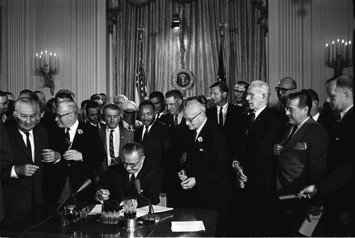 President Johnson signs the Civil Rights Act of 1964 as King looks on