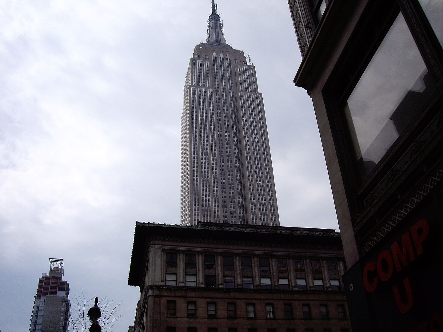 the empire state building viewed from below against a blue sky