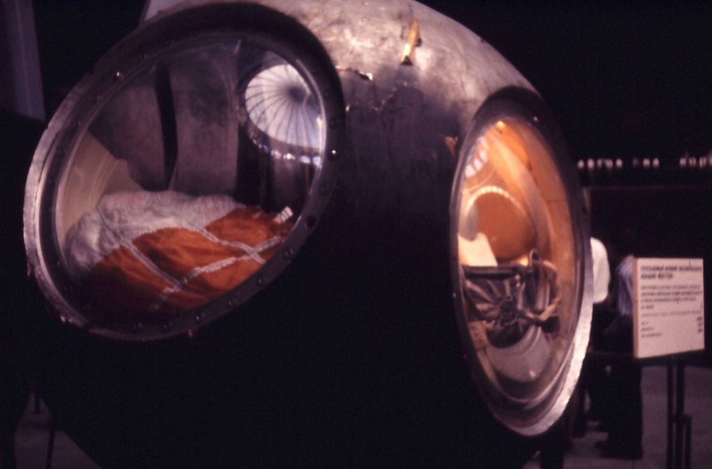 the scorched spherical vostok 1 descent capsule on display in a museum
