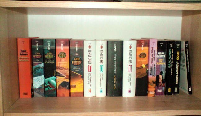 a bookshelf lined with editions of isaac asimov's foundation cycle and other novels