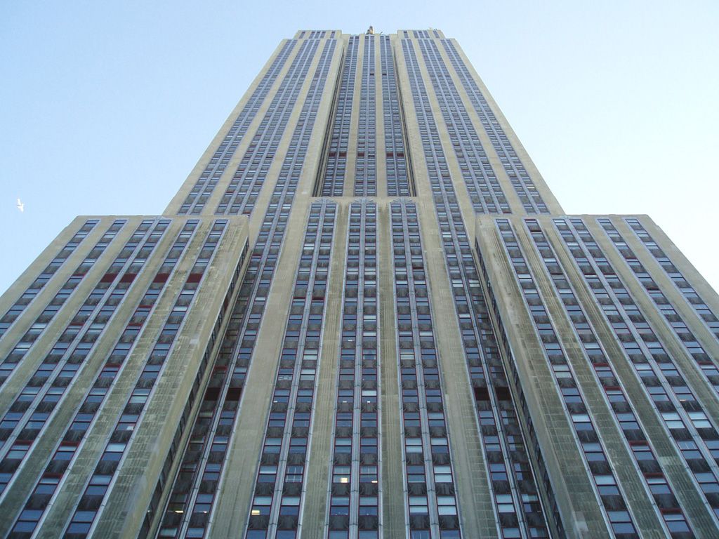 looking straight up at the empire state building from street level