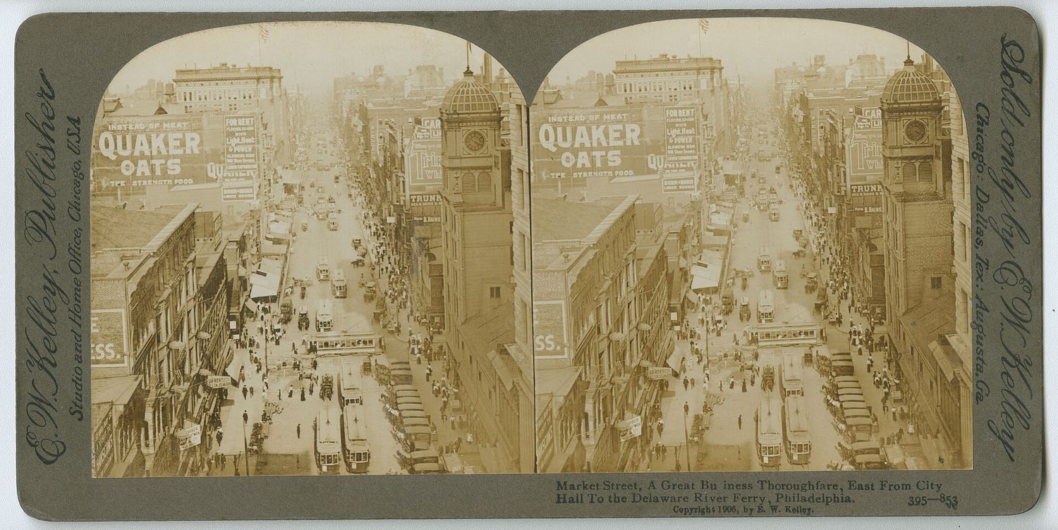 A crowded early-automobile city street