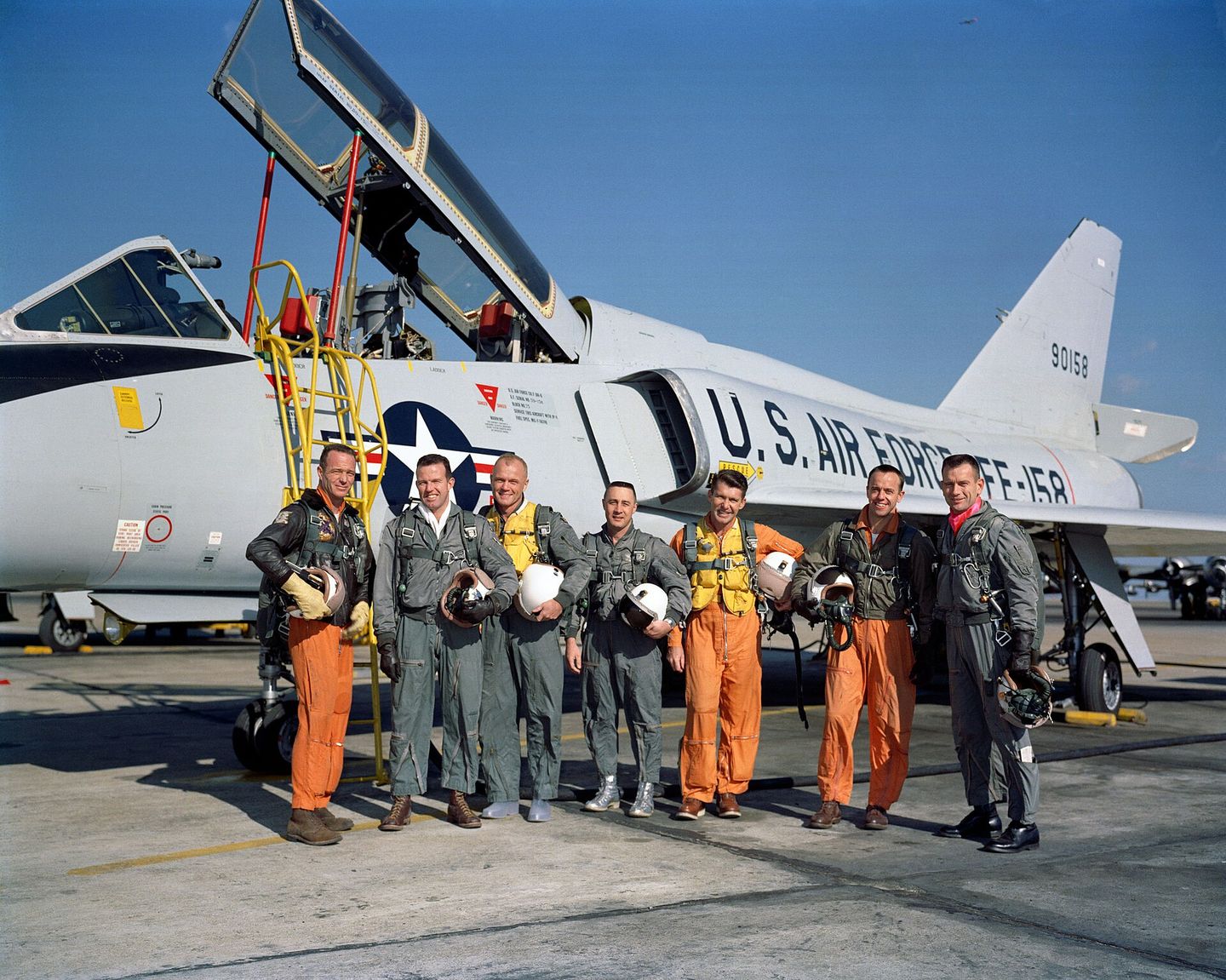 mercury seven astronauts posing with a u.s. air force aircraft