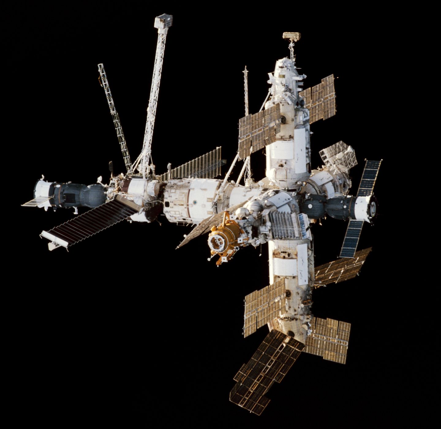 The Russian space station Mir photographed from a docking space shuttle, showing its modular construction against the black of space