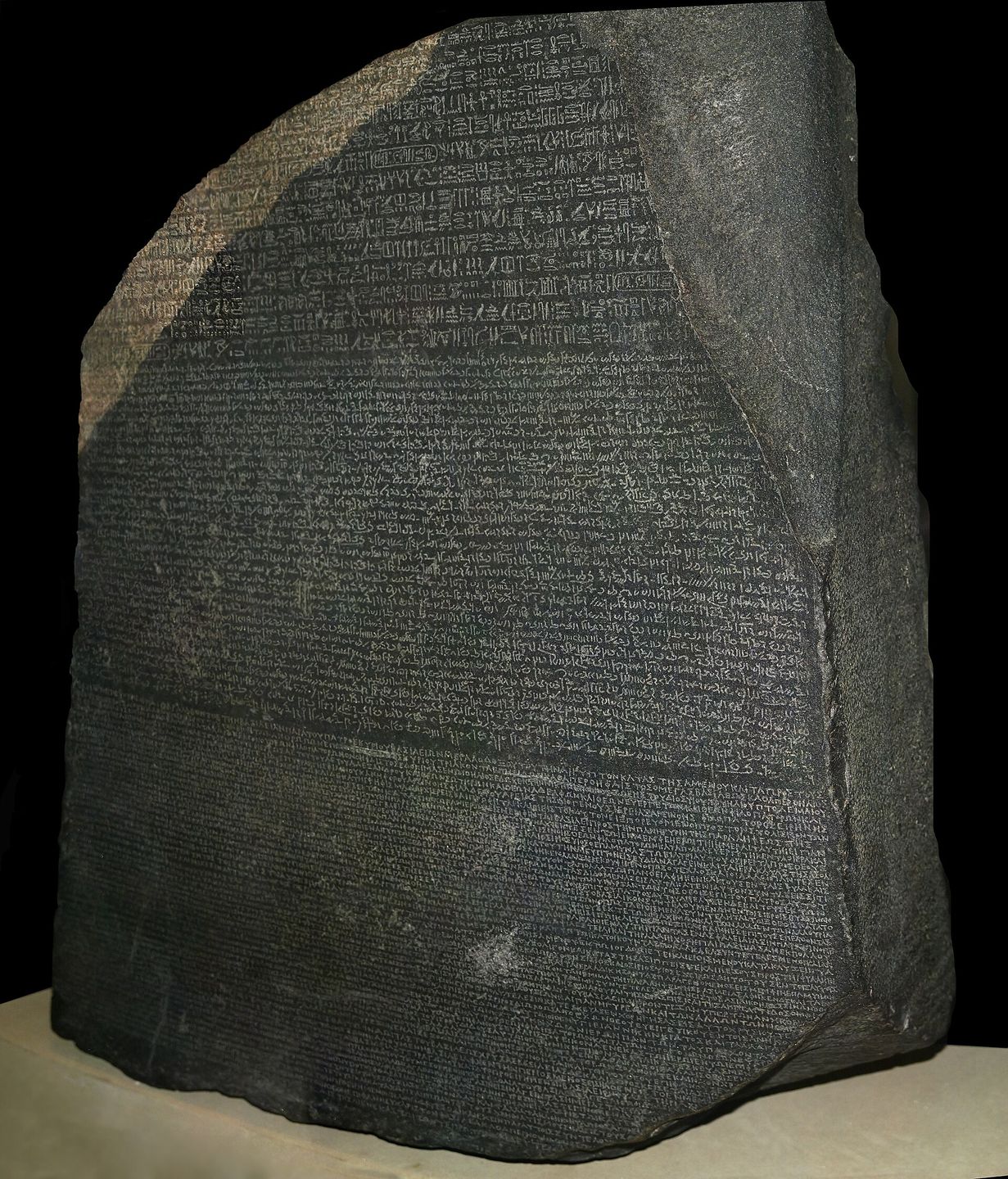 the rosetta stone on display at the british museum, carved with inscriptions in hieroglyphics, demotic, and greek