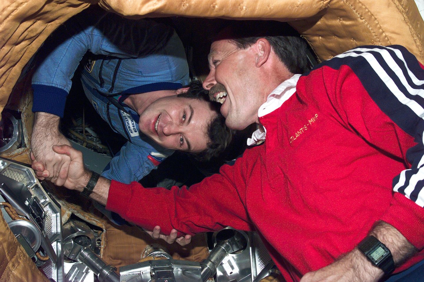 STS-71 commander Hoot Gibson shaking hands with Mir-18 commander Vladimir Dezhurov at the docking hatch, a historic meeting of American and Russian space programs