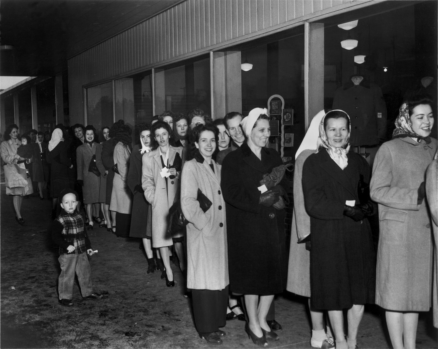 Women standing in line outside a department store to buy nylon stockings